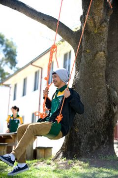 Male student on swing outside Mary White College