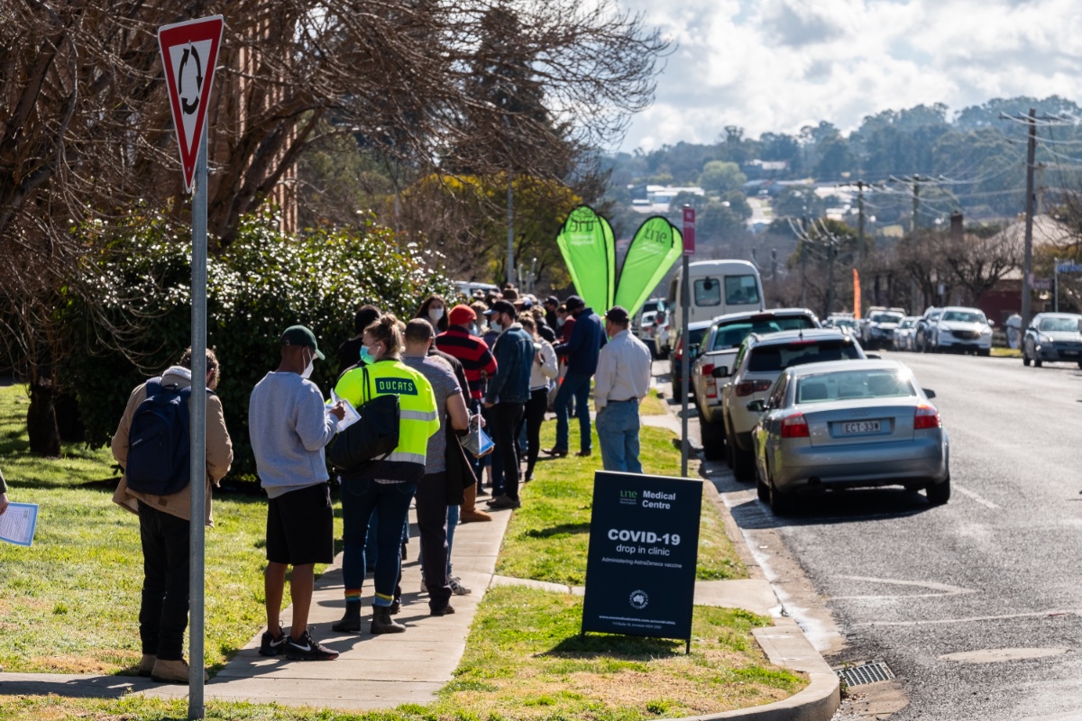 People queue for a UNE vaccination clinic