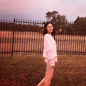 UNE Accounting graduate poses in front of fence