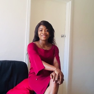 UNE Master of Social Work graduate smiles in a scarlet dress.