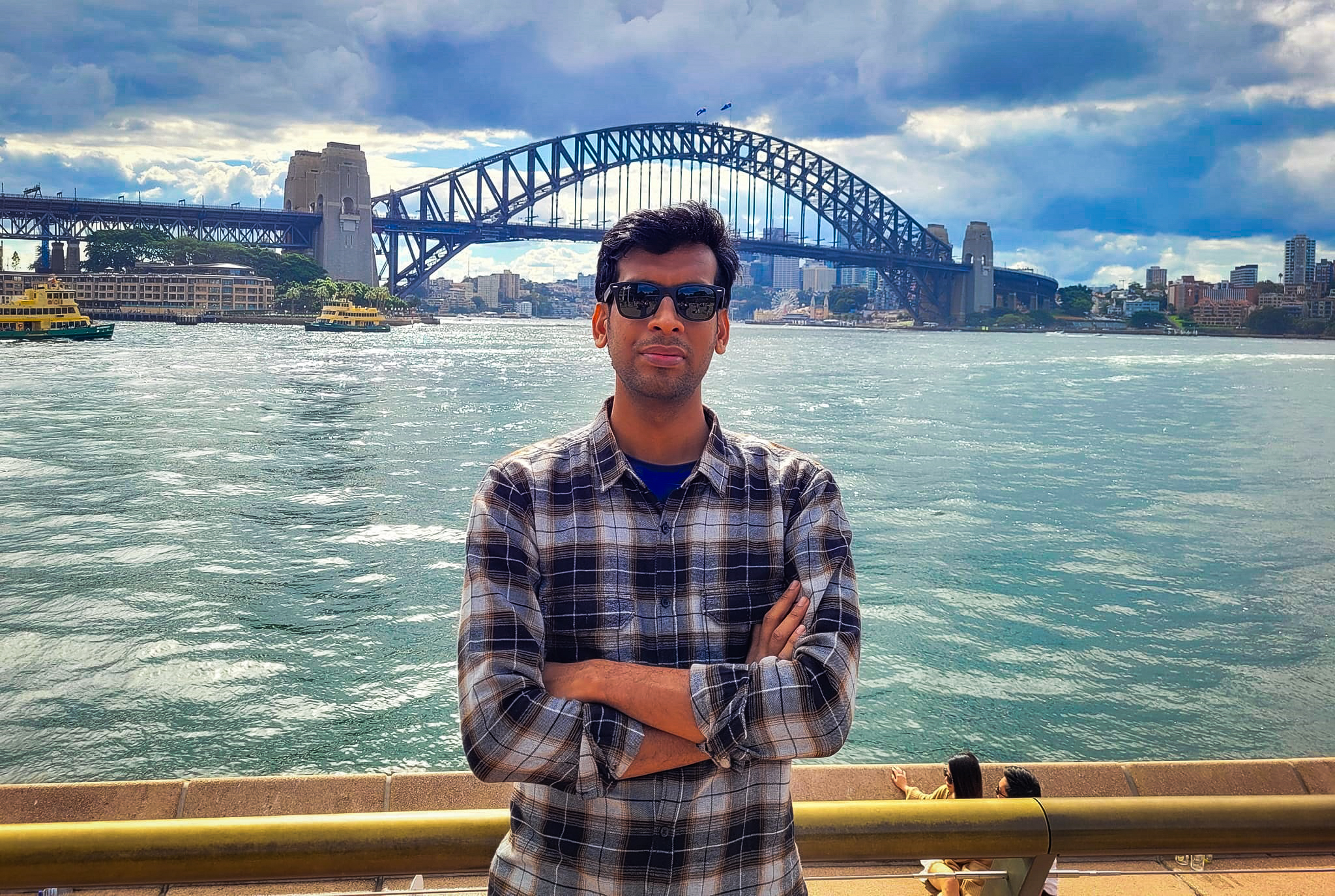 UNE Phd Student from Bangladesh poses for photo infront of water at Sydney Habour. 