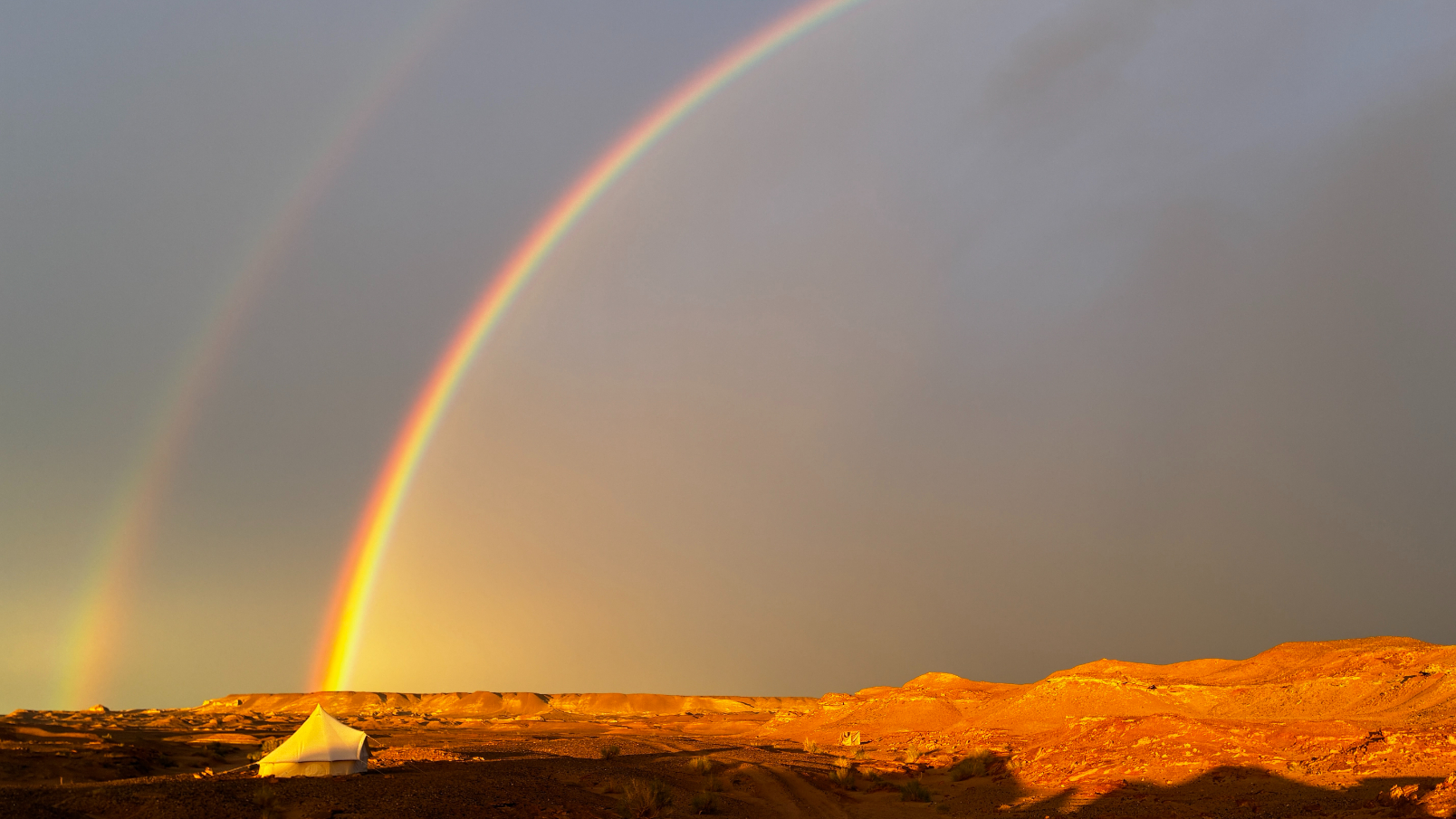 A rainbow hitting the campsite in the desert 