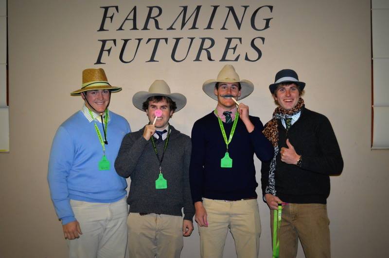 4 male students dressed up for photo booth in front of Farming Futures sign