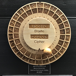 Circular wooden coding device with indented panels and raised dots 