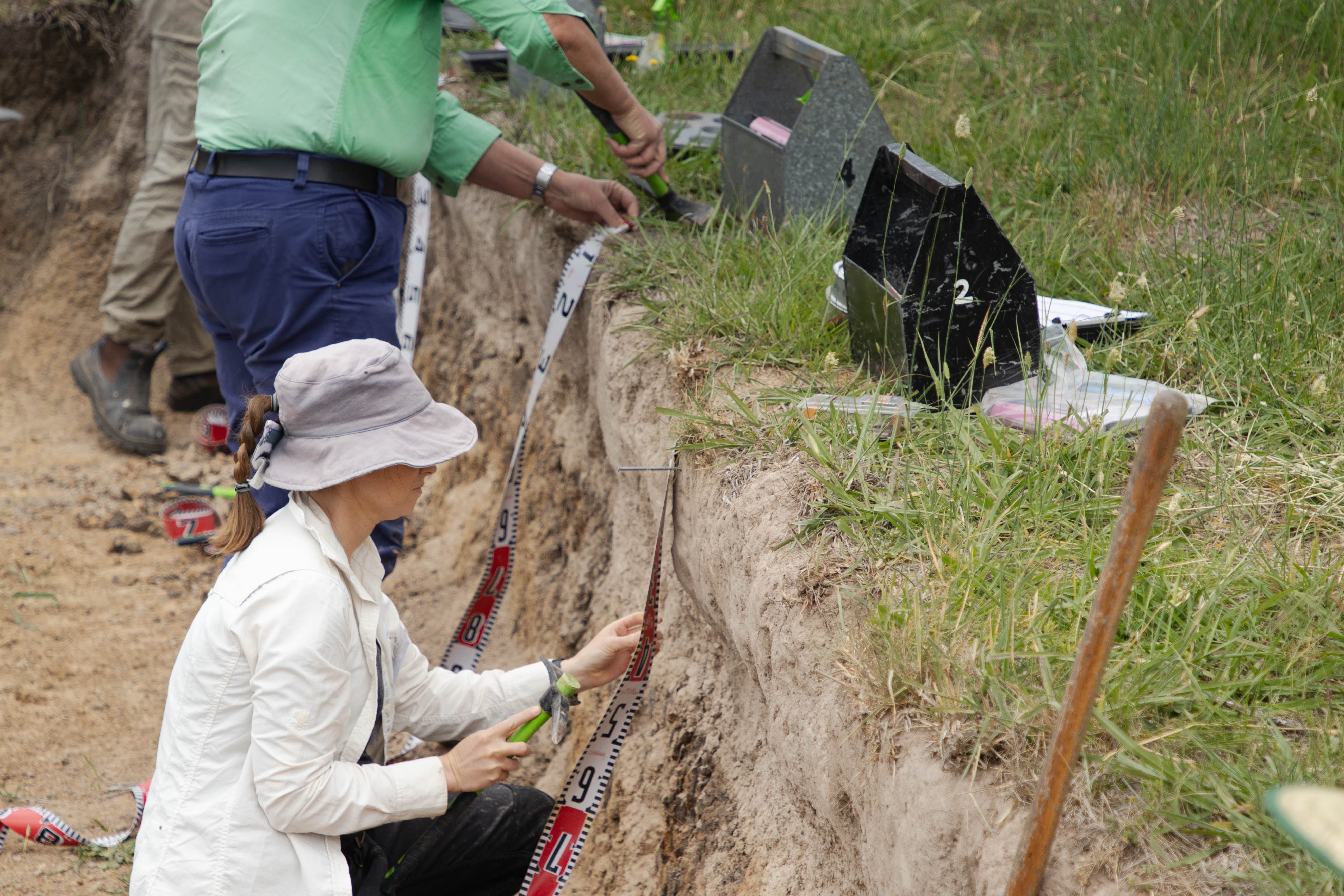 Woman analyses soil in a soil pit