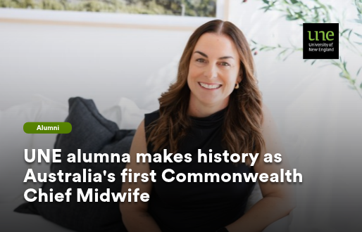 A professional portrait of Olivia Tierney, a woman with long brown hair, smiling warmly at the camera. She is wearing a black sleeveless top and is seated in a bright, light-filled room with soft furnishings and greenery visible in the background. A green 