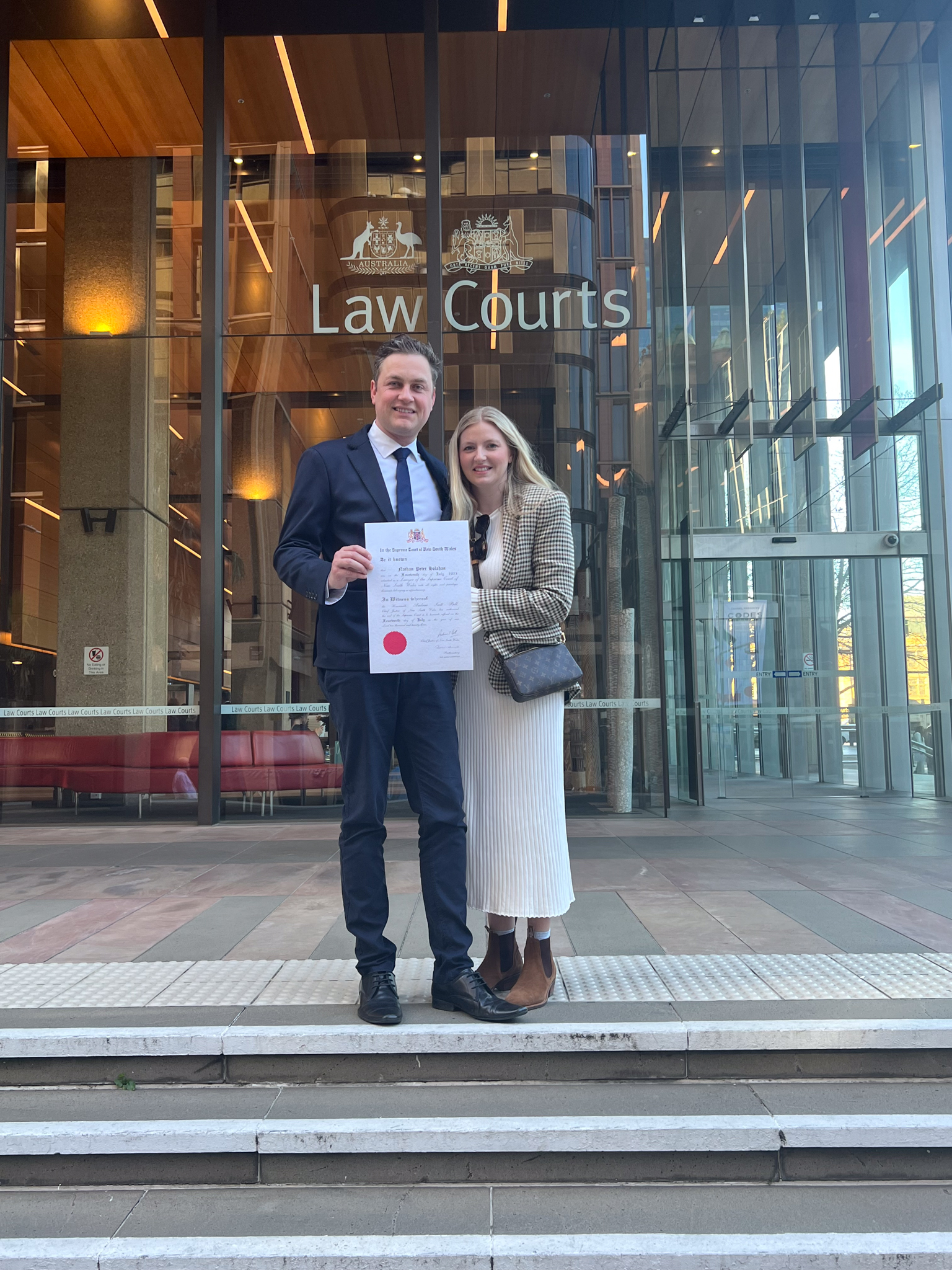 Man and wife in front of hight court with certificate 