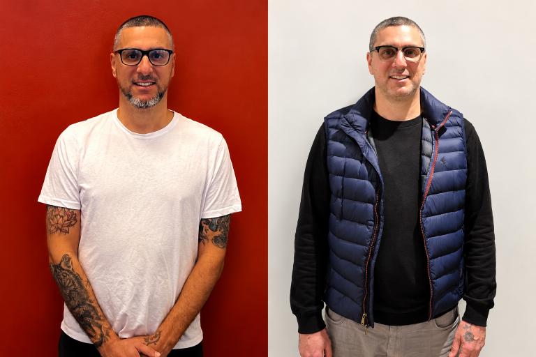 Two side-by-side portraits of Paul Rodgerson. On the left, Paul stands against a red wall wearing a white t-shirt, his tattooed arms clasped in front of him, photographed at Loddon Prison in 2025. On the right, Paul stands against a white wall wearing a navy puffer vest over a black long-sleeve top, photographed in 2026.