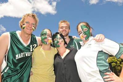 group of students in sports shirts and green and white face paint