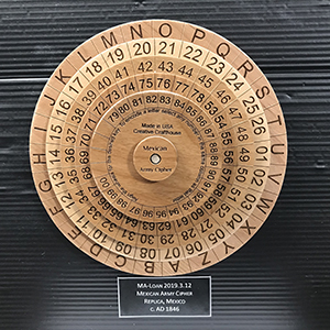 Intricate coding device of five concentric wooden wheels with numbers and letters around the edge of each