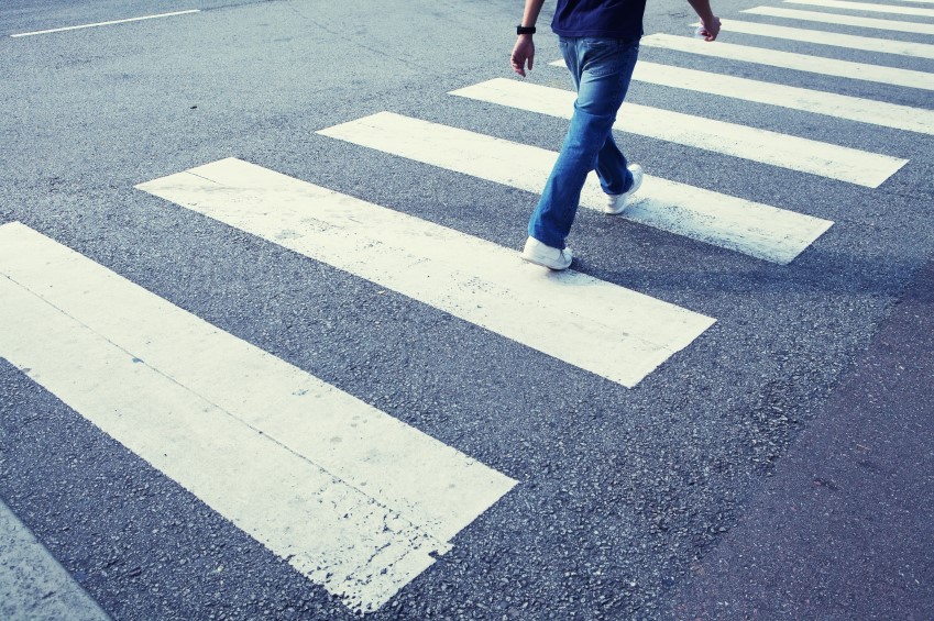a pedestrian crossing is painted on the road with thick white stripes (sometimes yellow)