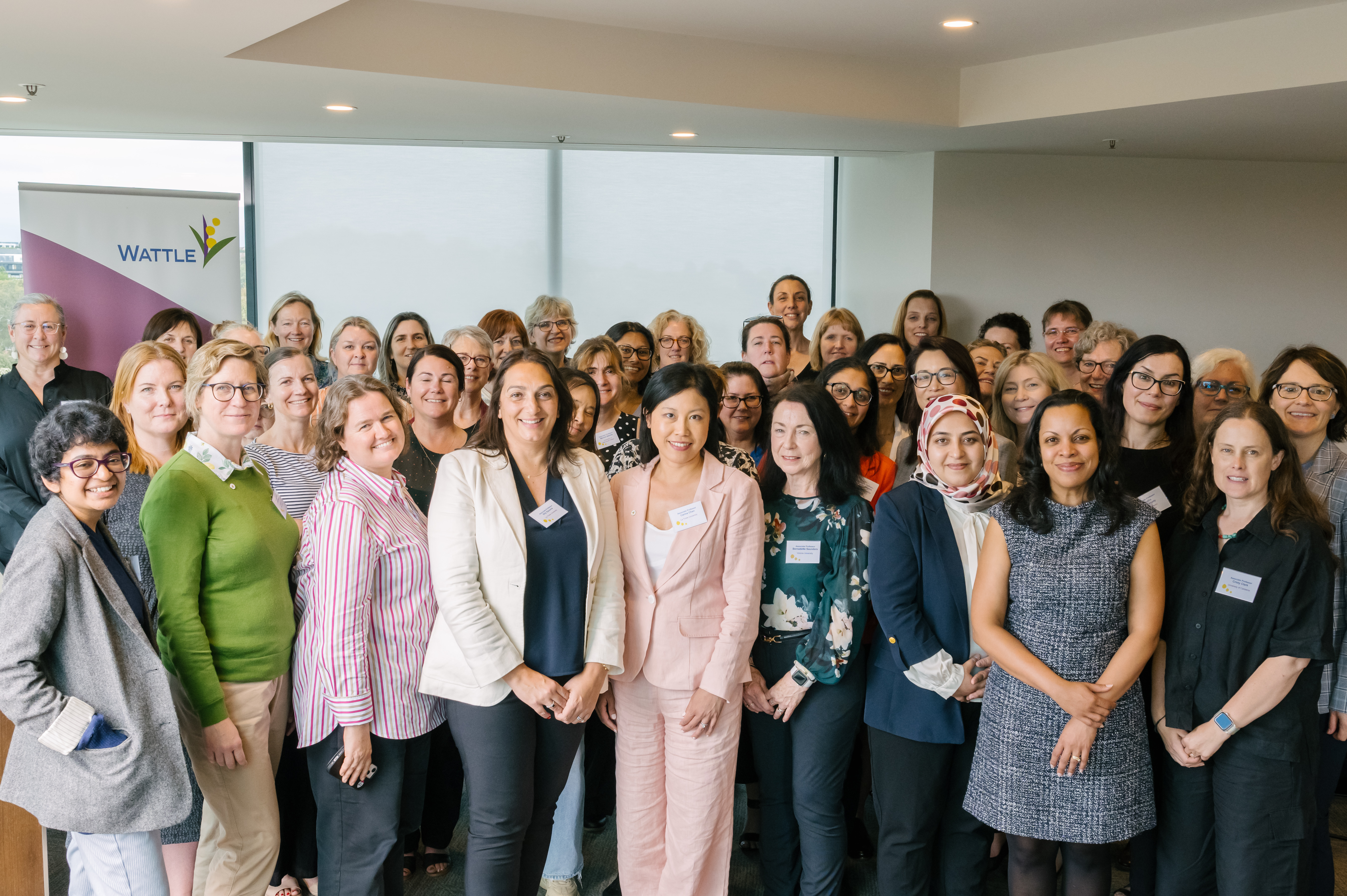 Group photo of women smiling inside a room at leadership event