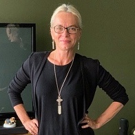Narrative Therapist and Adjunct History Lecturer Nicole Conner smiles to camera with hands on hips