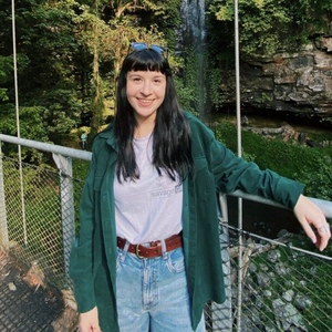 UNE Bachelor of Media and Communications student Sara Perry poses in front of waterfall