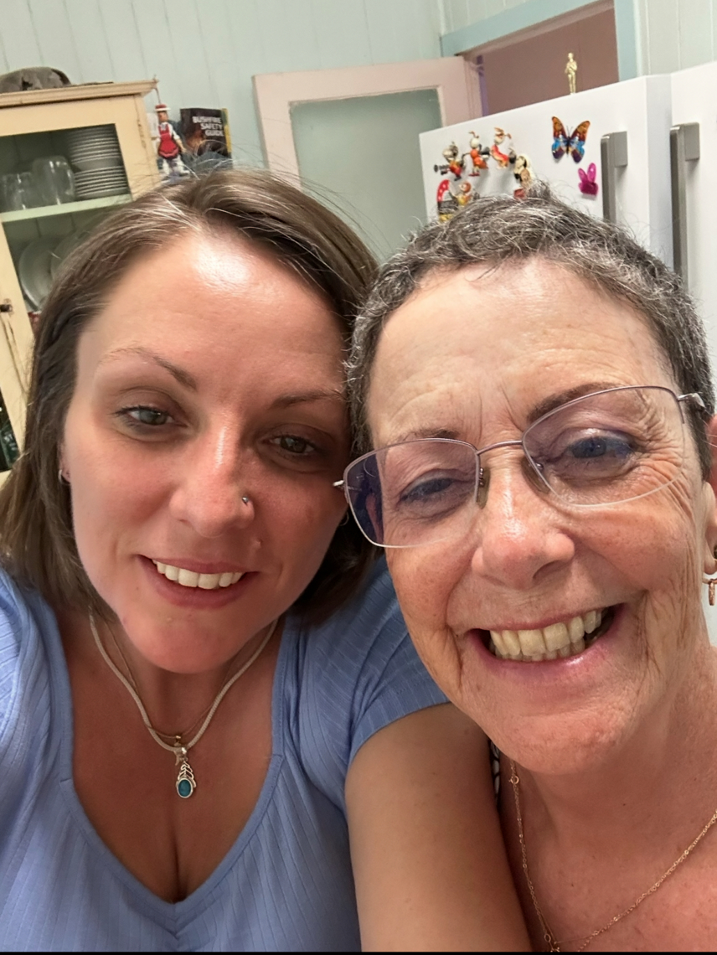 Adult daughter takes a self-photo with her mother.