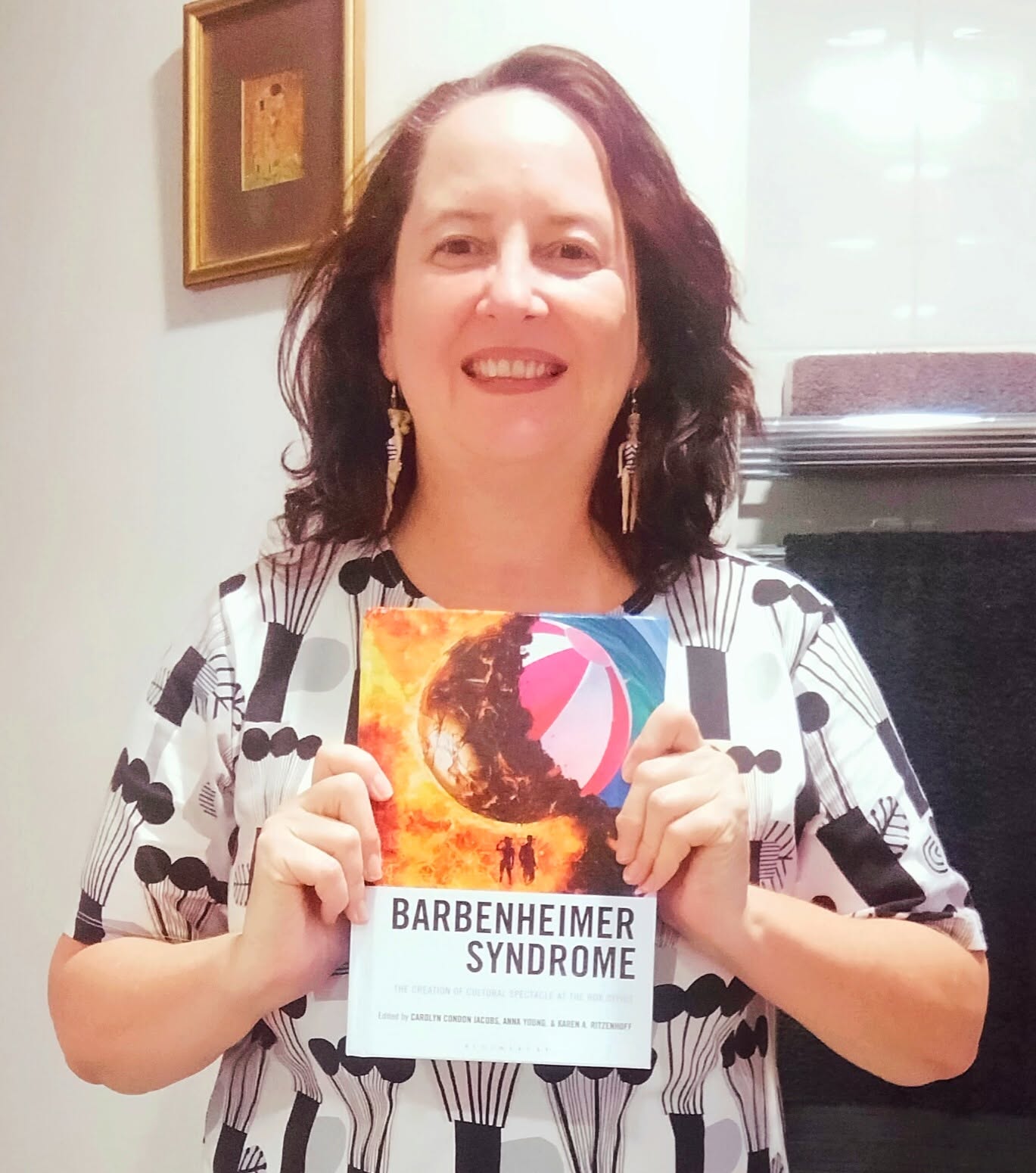 PhD candidate Rebekah Brammer holds a book on Barbie she has been published in