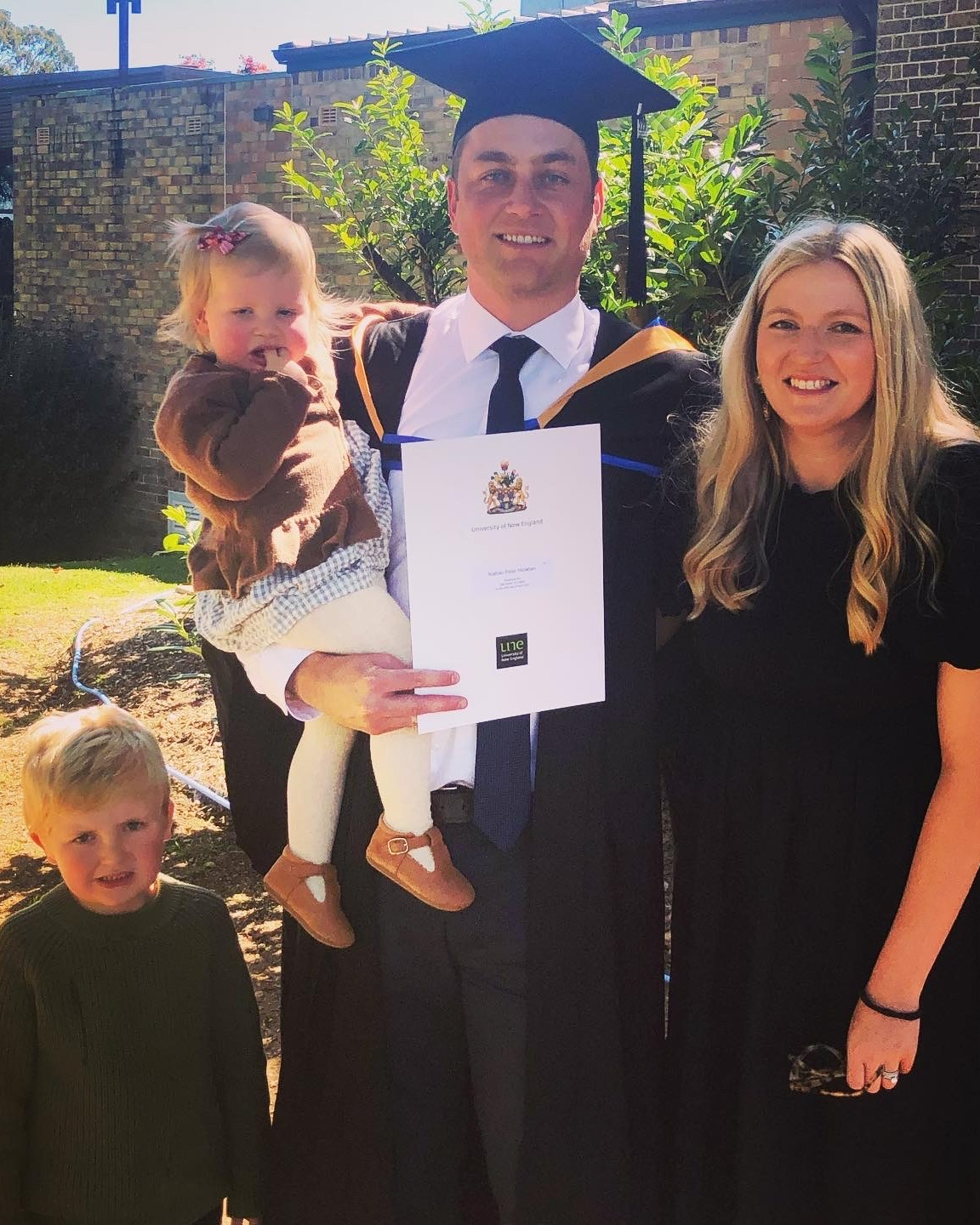 Man with wife and two small children at graduation