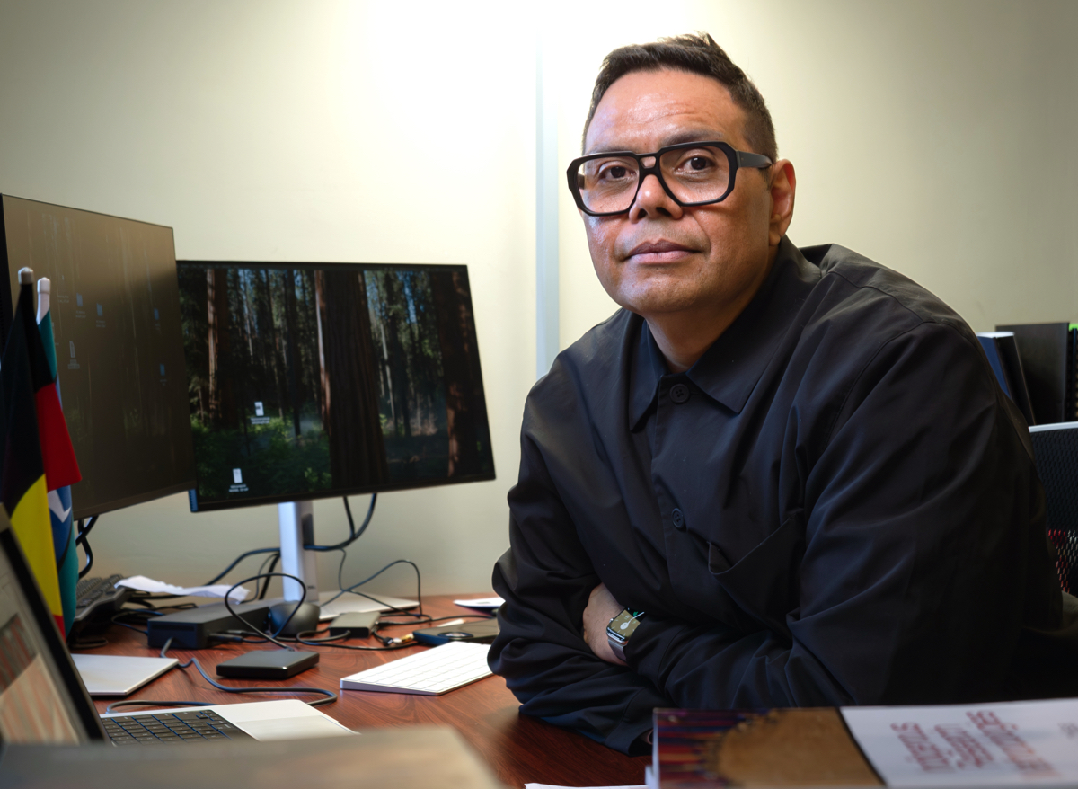 indigenous man at desk looking at camera