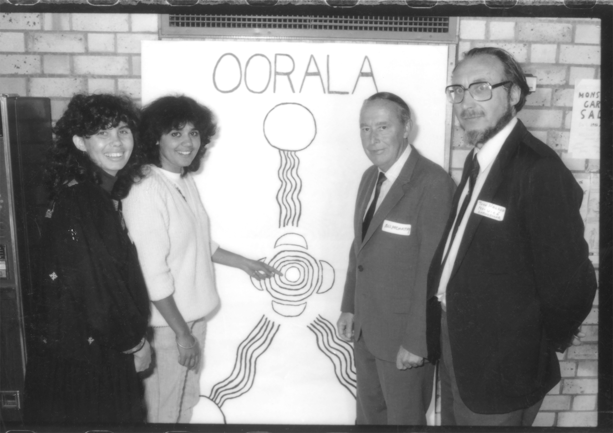 Oorala: The Beginning 1986-two women plus two men pointingat the Oorala symbol