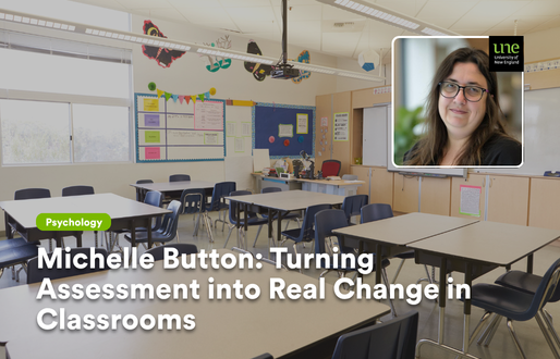 Bright, empty primary school classroom with desks and chairs arranged in groups and colourful displays on the walls, with an inset portrait of Michelle Button wearing glasses and smiling, alongside the UNE logo, and the text “Michelle Button: Turning Assessment into Real Change in Classrooms”.