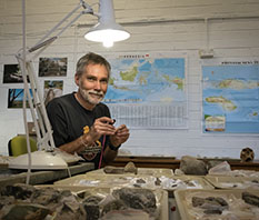 Associate Professor Mark Moore examining ancient stone artefacts in a lab