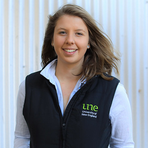 UNE Bachelor of Biomedical Science graduate Andrea Jaggi smiles to camera in UNE vest