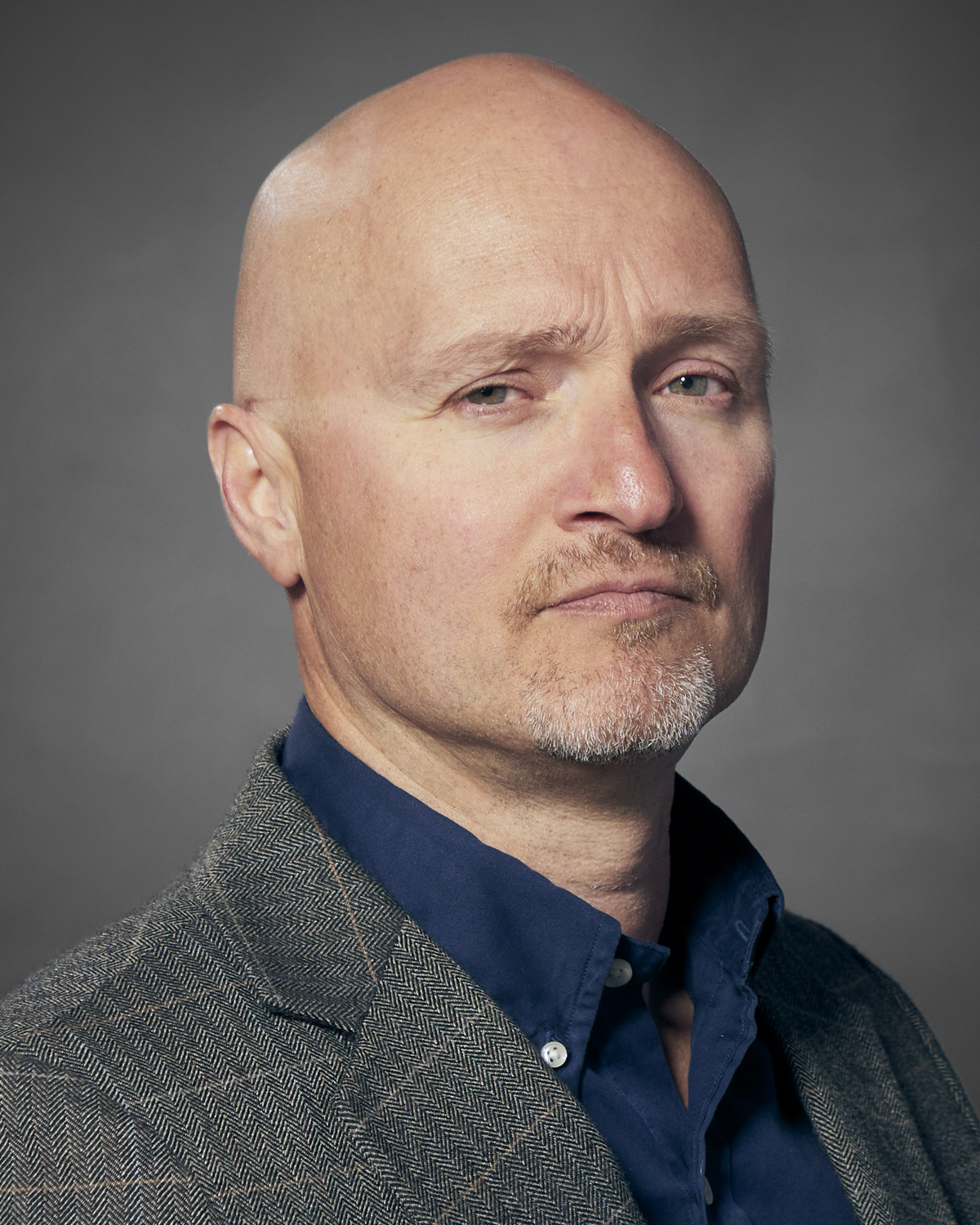man looks at camera in head-and-shoulders portrait