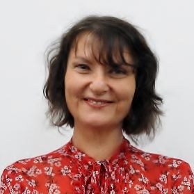 Portrait image of Dr Brankovic smiling at the camera wearing a red patterned shirt. She has short, dark hair.