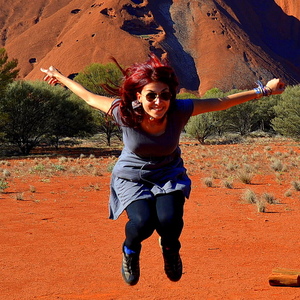 Bachelor of Arts graduate Donatella D'Anniballe leaps in the air in front of Uluru