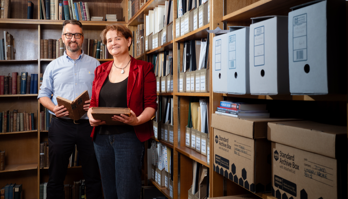Two people surrounded by shelves of books
