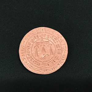 Coin-like terracotta stamp with etched Middle Eastern inscription