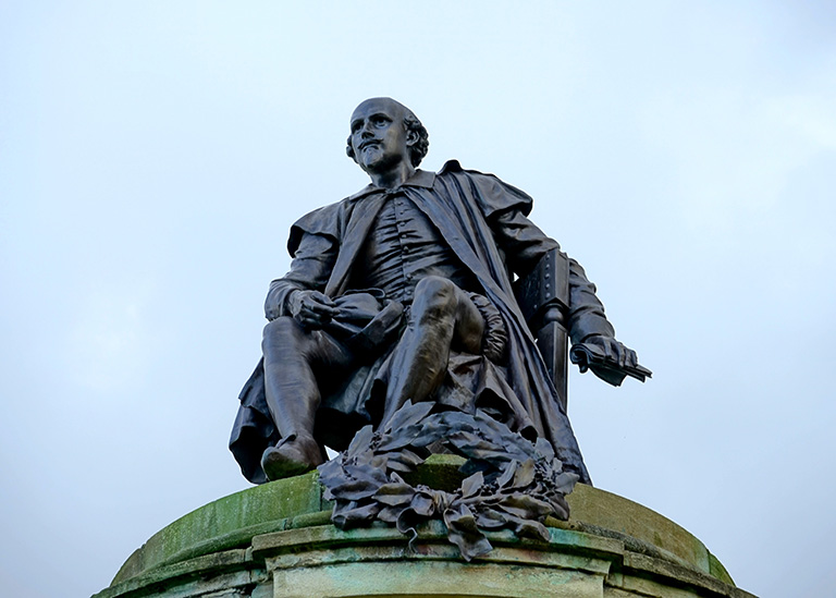 Steel-coloured statue of old-fashioned man on a building