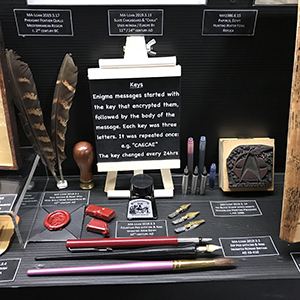 Exhibition display cabinet with feather quills, ink pots, wax, nibs and pens