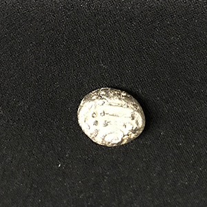 Small lump of metal that is an ancient coin 