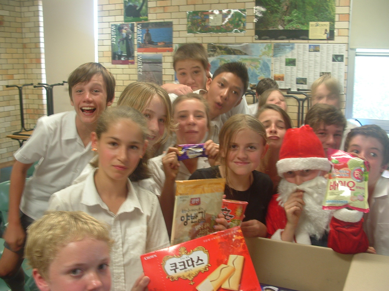 Students showing off their Christmas gifts with Santa.