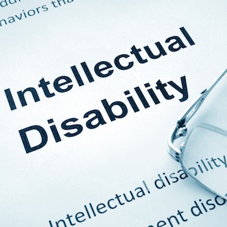 Intellectual disability printed on paper with reading glasses sitting on the paper.