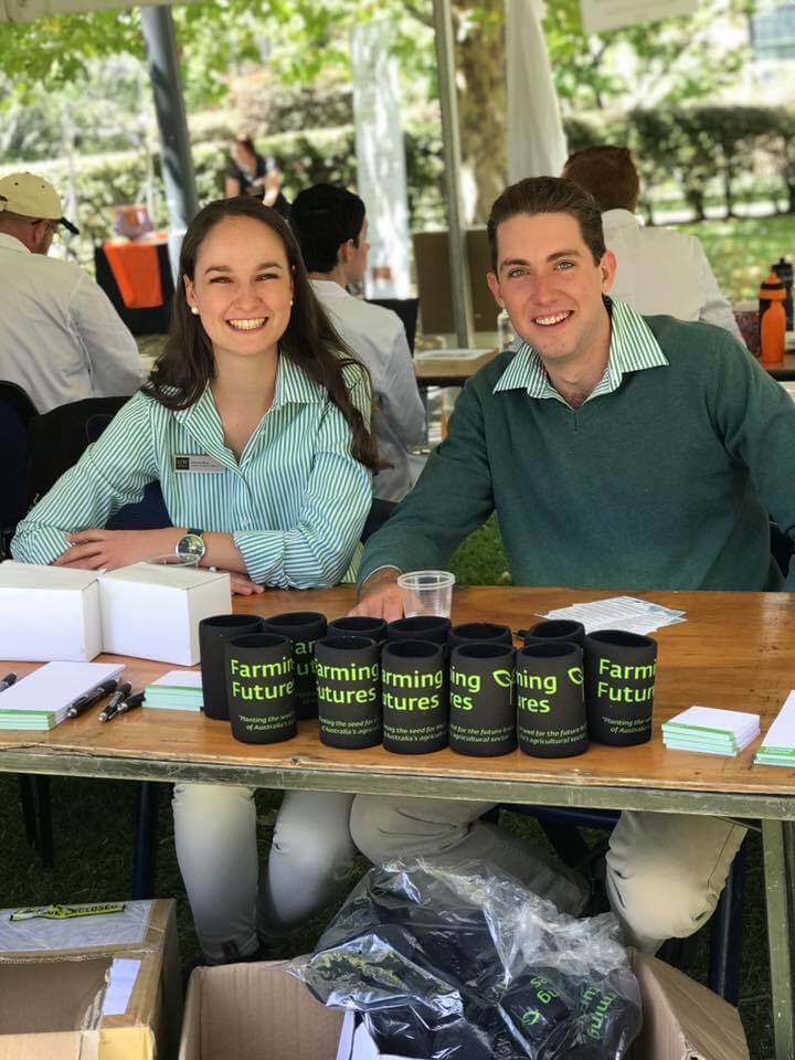 Female and Male student sit at desk in Farming Futures uniform with farming futures merchandise 