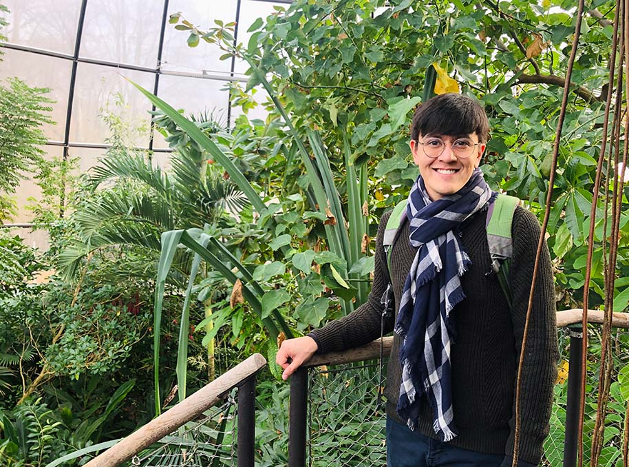 Ryan O'Donnell stands next to a railing with large plants in the background.