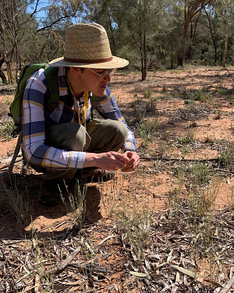 Ryan O'Donnell looking at plants on the ground while out in the field.