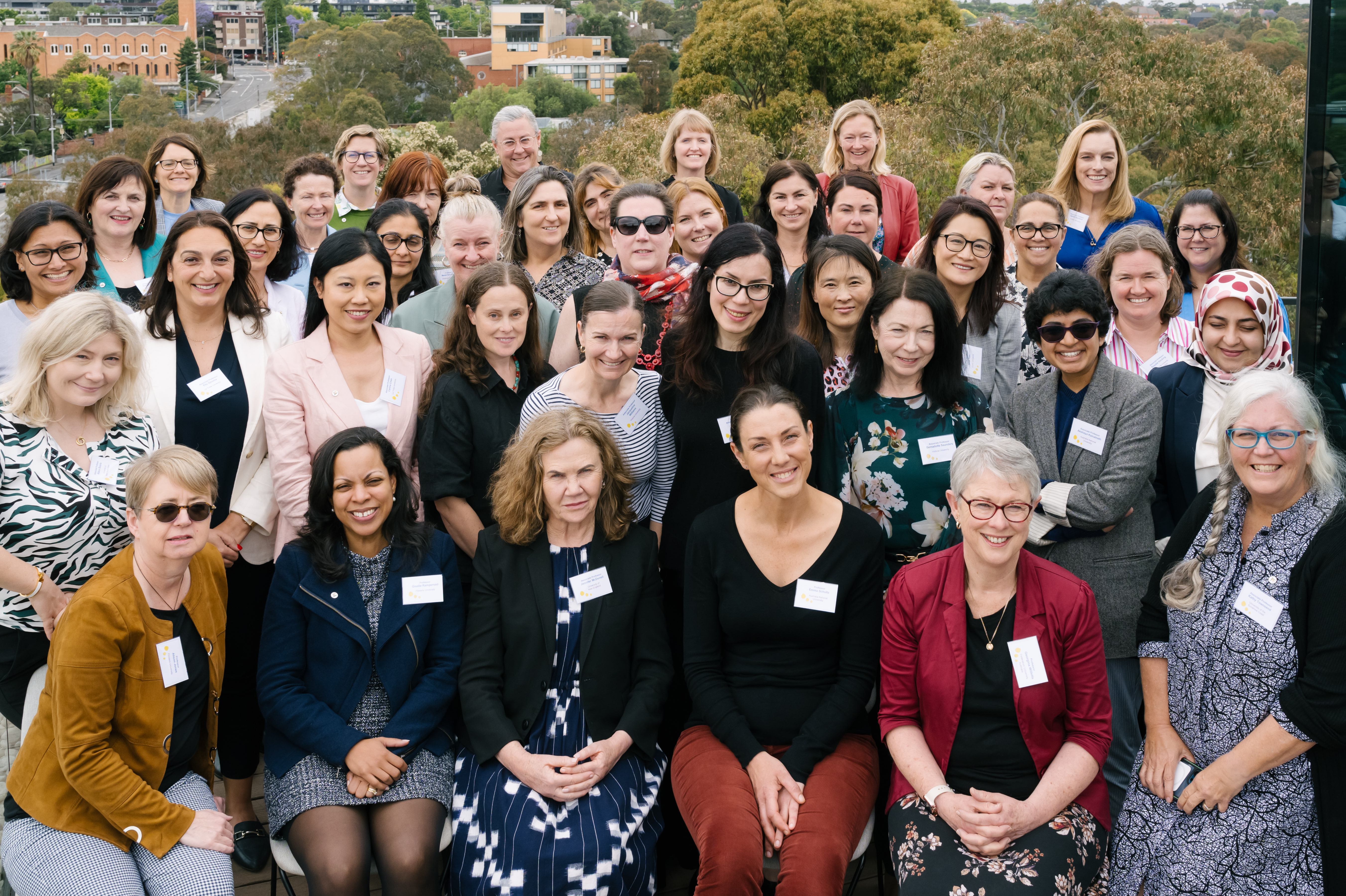 Outside group photo of female university worker smiling at event 