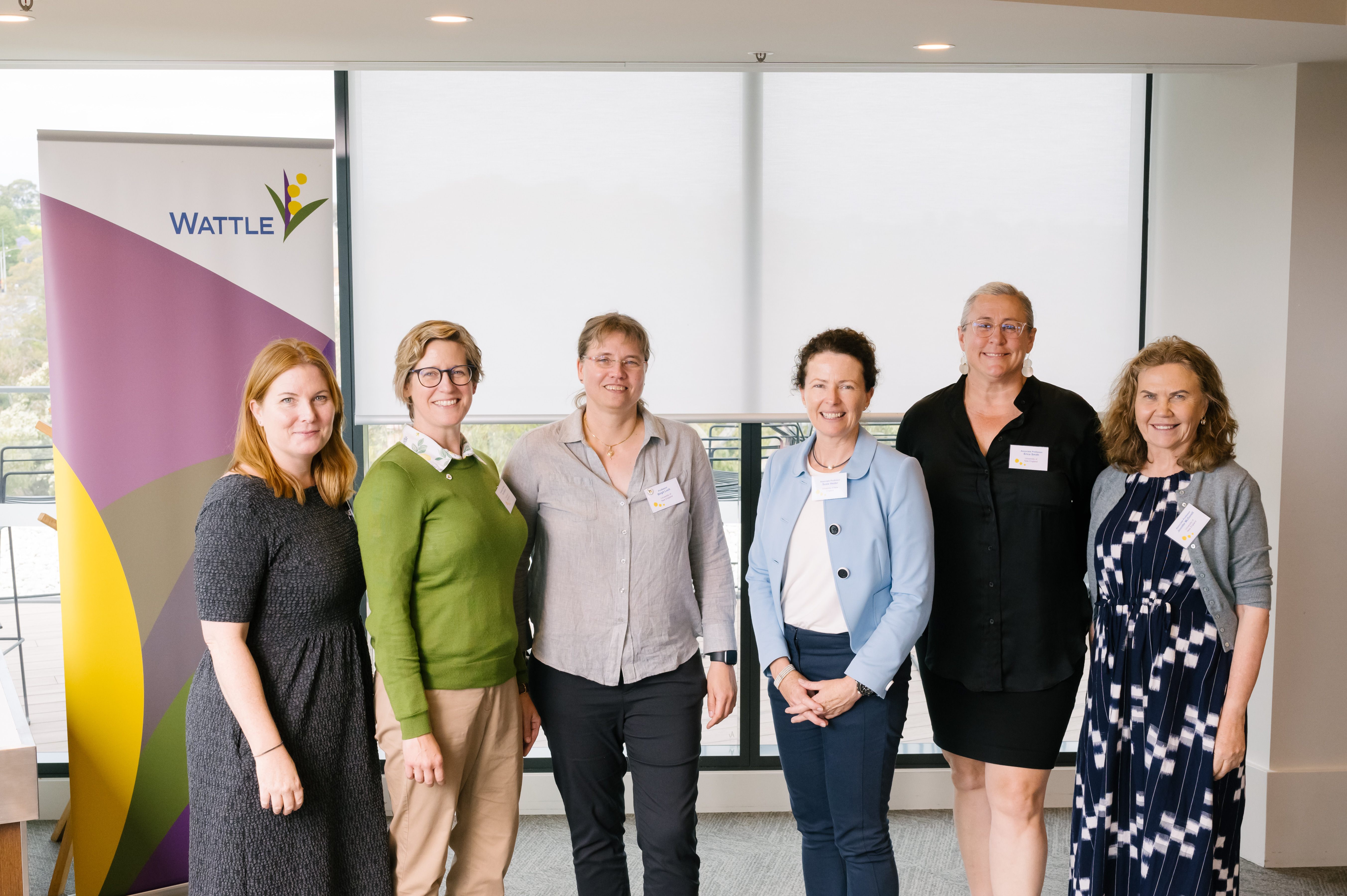 Female University Academics standing inside for a group-shot at leadership event. 