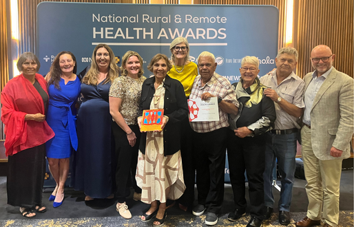 A group photo of men and women in formal attire at they hold their award at the National Rural Health Awards night. 
