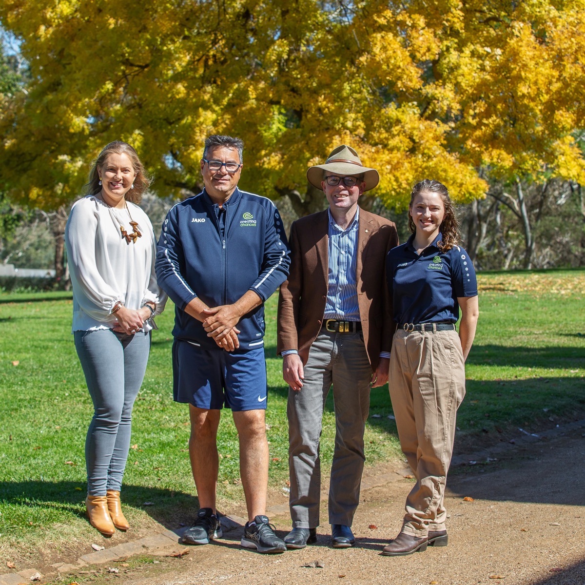 People posed for photo in front of autumnal tree