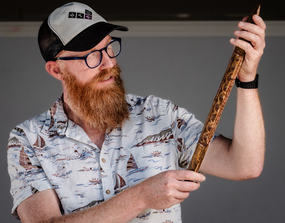 Dr Piers Kelly with a message stick of unknown provenance.