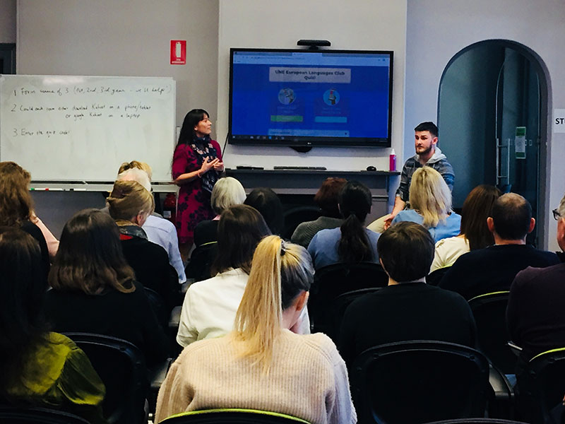 Seminar room at UNE Sydney with two speakers and a large audience group