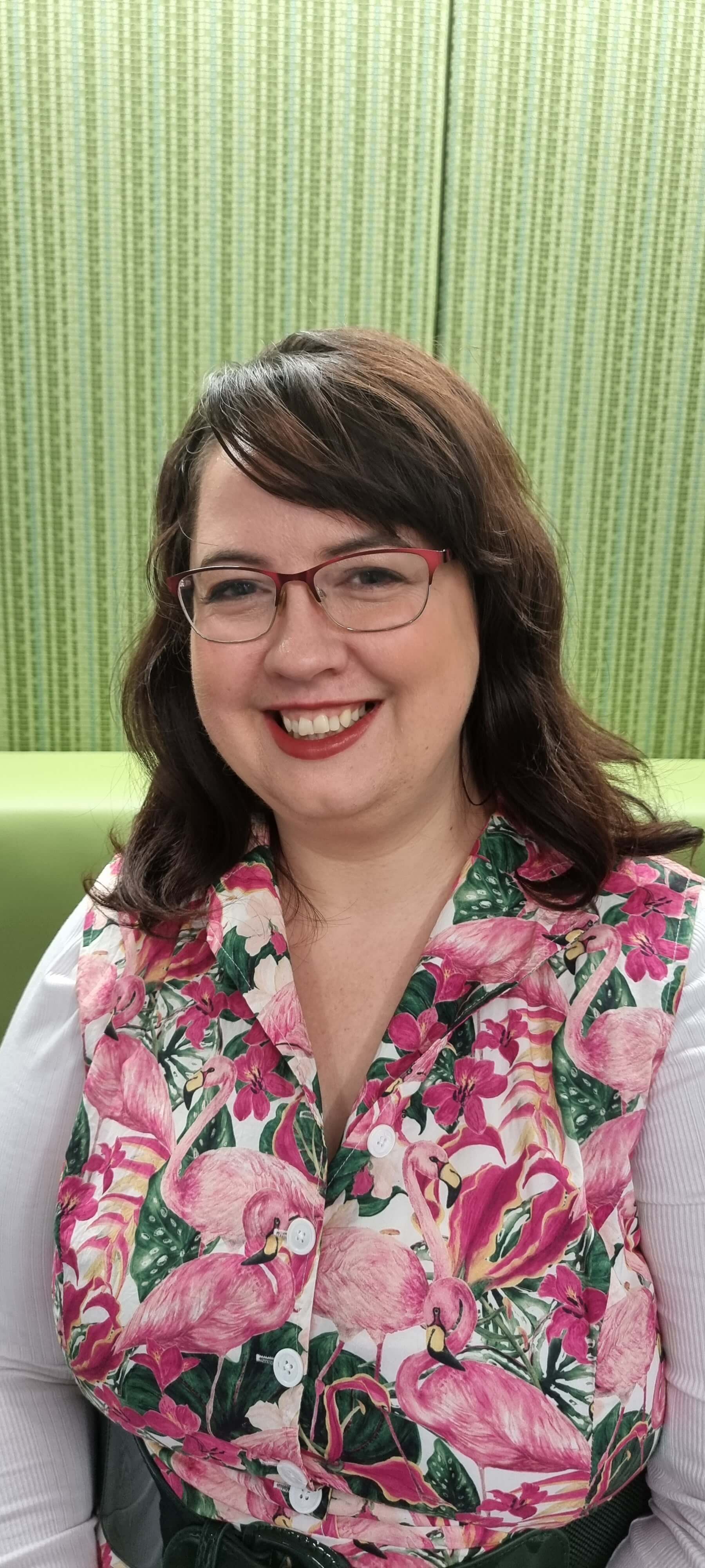 A woman in pink smiles