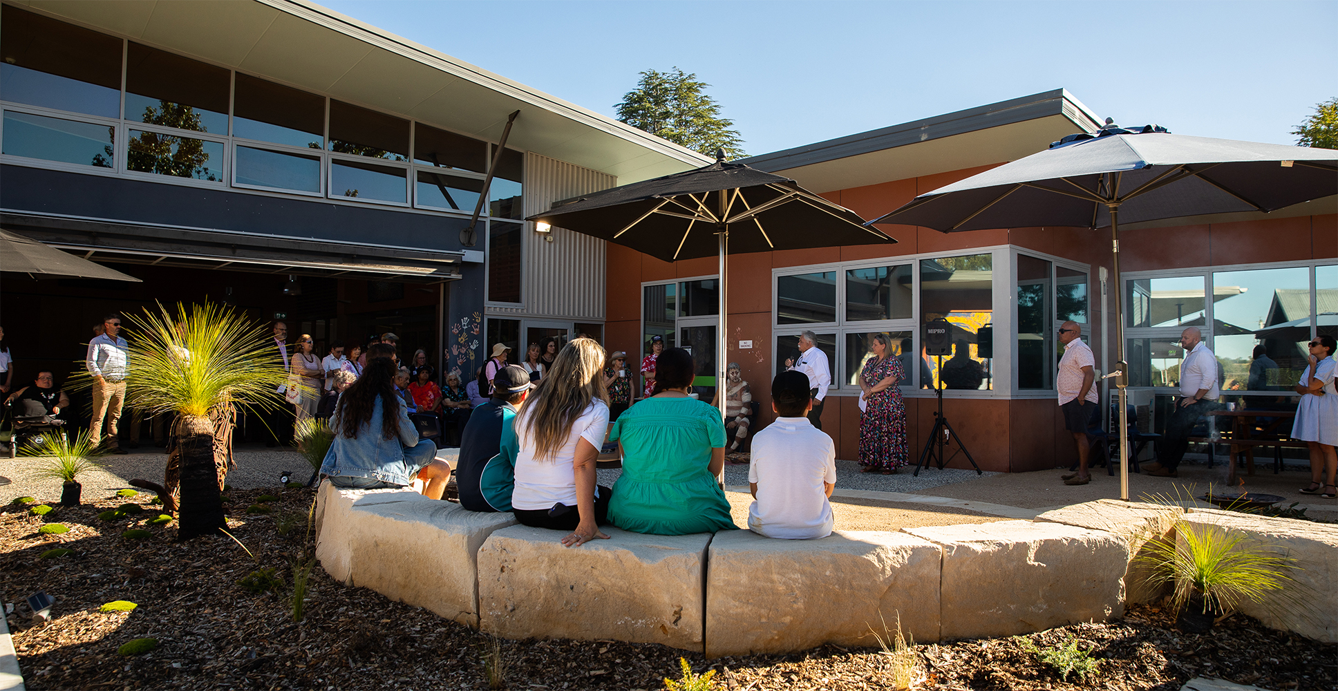 Oorala's social courtyard area filled with staff and students and elders listening to Uncle Steve talk.