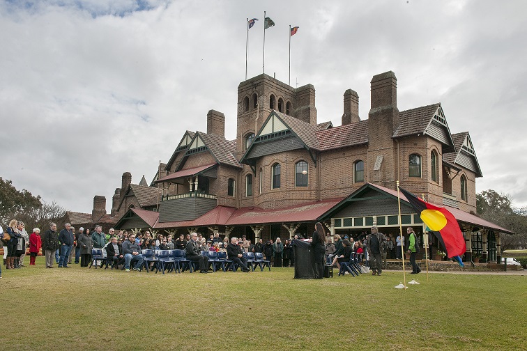 Naidoc gathering with the Aboriginal flag outside Booloominbah from the Southern Lawn
