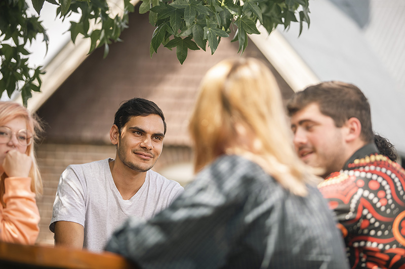 students sitting at table outside