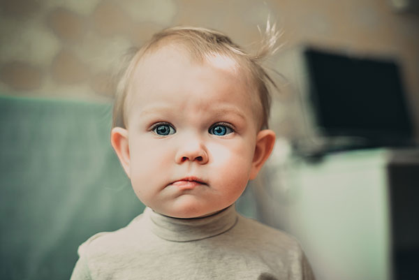 A toddler looking serious or doubtful